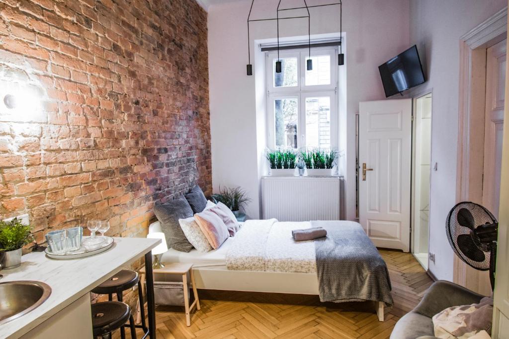 a bedroom with a bed and a brick wall at LION apartments in Krakow