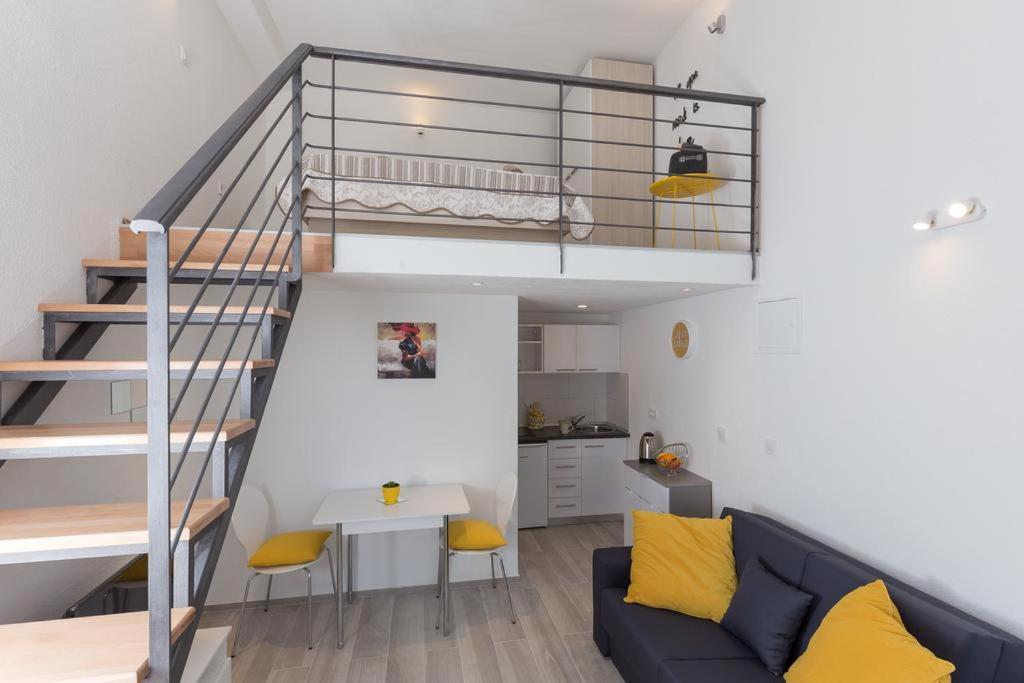 a living room with a blue couch and a staircase at Pomet Delux Studio in Dubrovnik