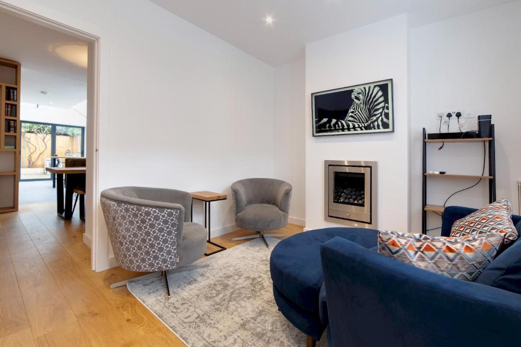 sala de estar con sofá azul y sillas en Bright Beautiful Modern 2 Bed Home Pass The Keys, en Cambridge