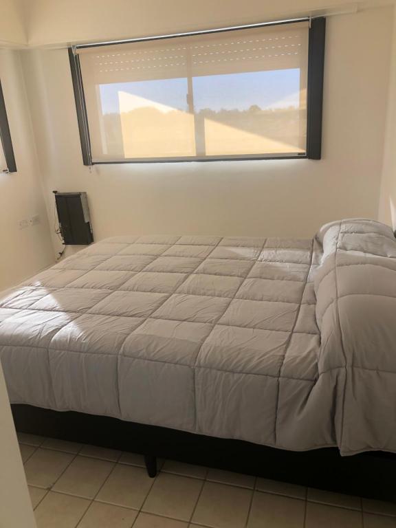 1 dormitorio con 1 cama grande y ventana en Departamentos 3 Ambientes Cochera Punta Mogotes en Mar del Plata