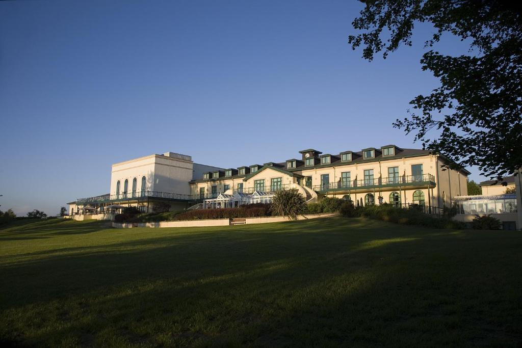 a large building on top of a lush green field at Vale Resort in Hensol