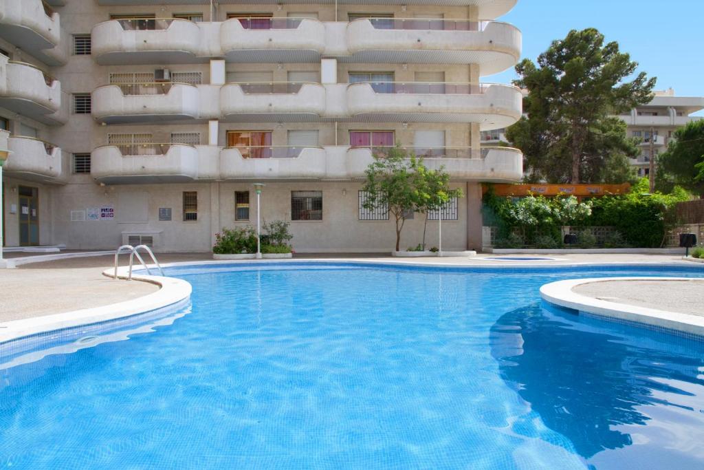 a swimming pool in front of a building at Arquus Park in Salou