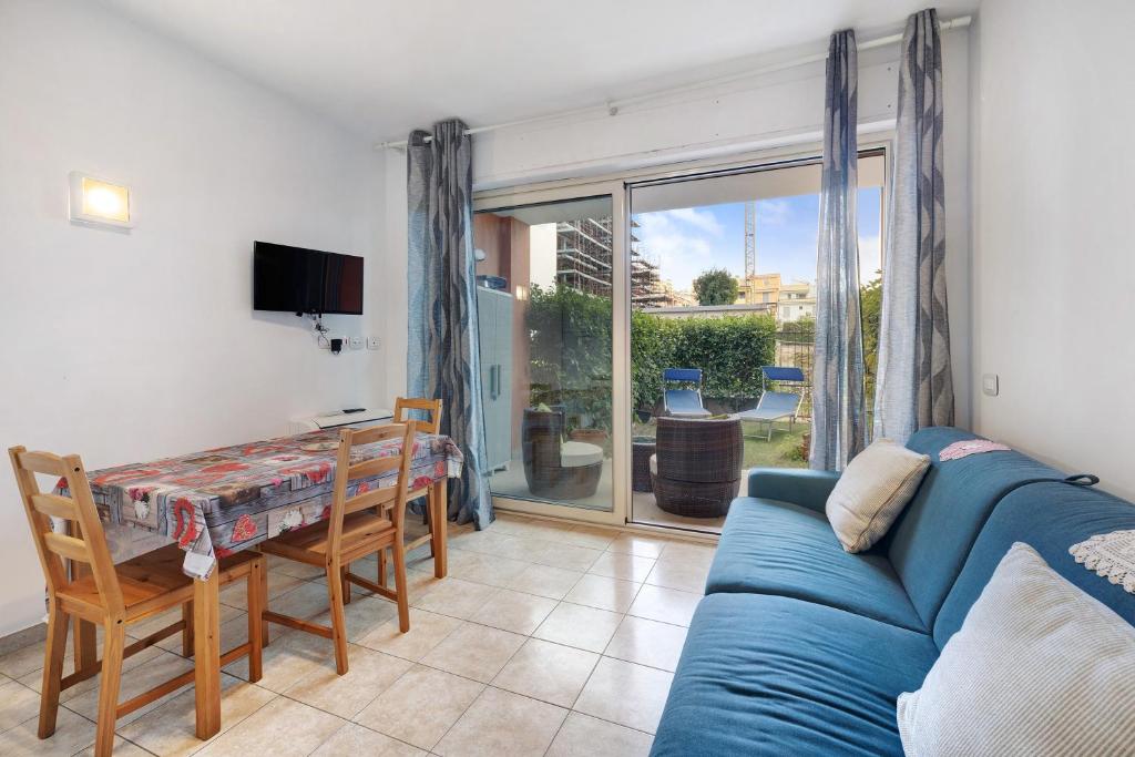 een woonkamer met een blauwe bank en een tafel bij Condomino Alba Chiara 6 in Loano