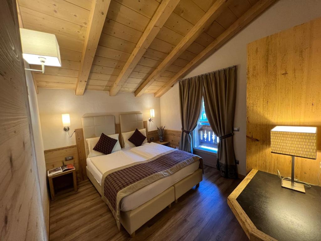 um quarto com uma cama grande e uma janela em Hotel Bondi em Livigno