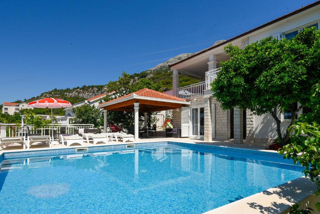 una piscina frente a una casa en Holiday Villa Perna, en Orebić