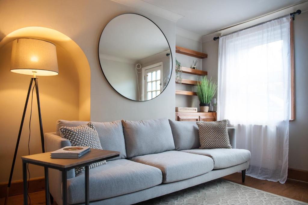 a living room with a couch and a mirror at Taylors Townhouse in Royal Tunbridge Wells