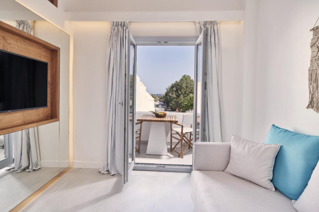 - un salon avec un canapé et une télévision dans l'établissement Nikki Beach Resort & Spa Santorini, à Kamari