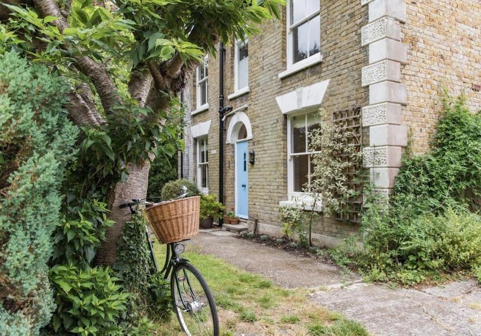 a bike with a basket parked next to a building at Poplar Farm House in Kent
