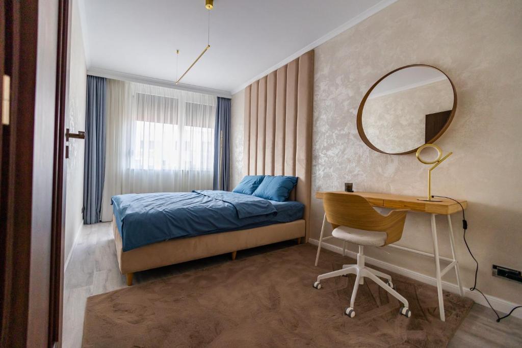 Schlafzimmer mit einem Bett, einem Schreibtisch und einem Spiegel in der Unterkunft Arad Residence - DeLuxe Blue Apartment in Arad