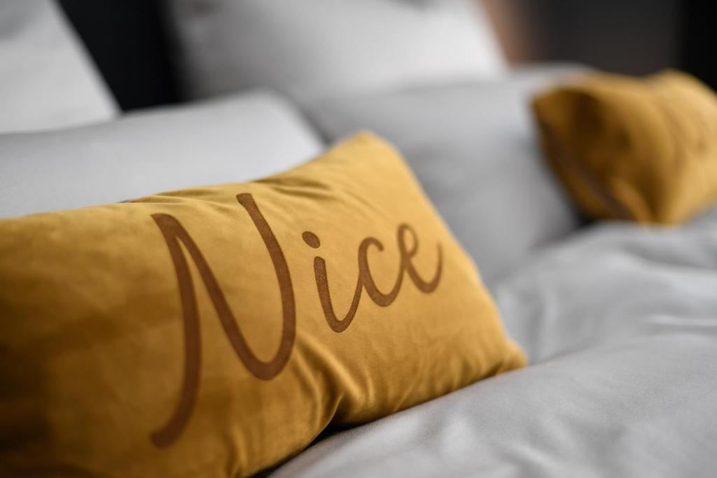 Una cama con una almohada amarilla con la palabra verdadera en Hotel Nice en Laupheim