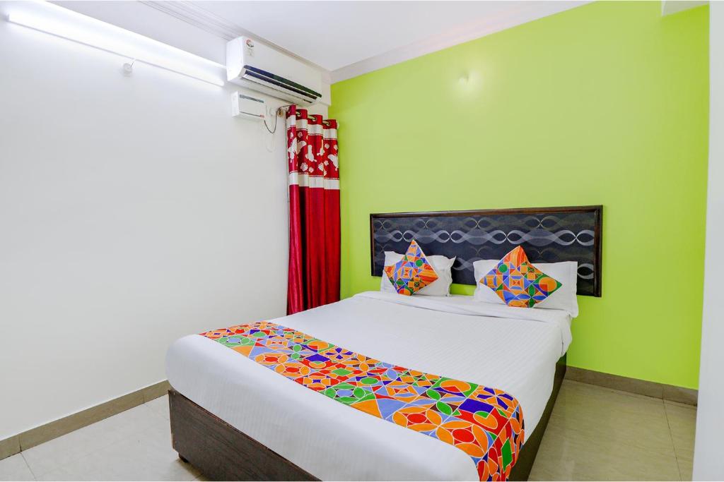 1 dormitorio con 1 cama y paredes verdes en FabExpress Ivory Pearl, en Bangalore