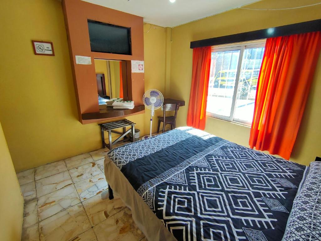 薩卡特卡斯的住宿－OYO Hotel Colón, Plaza Bicentenario, Zacatecas Centro，一间卧室配有床和红色窗帘的窗户