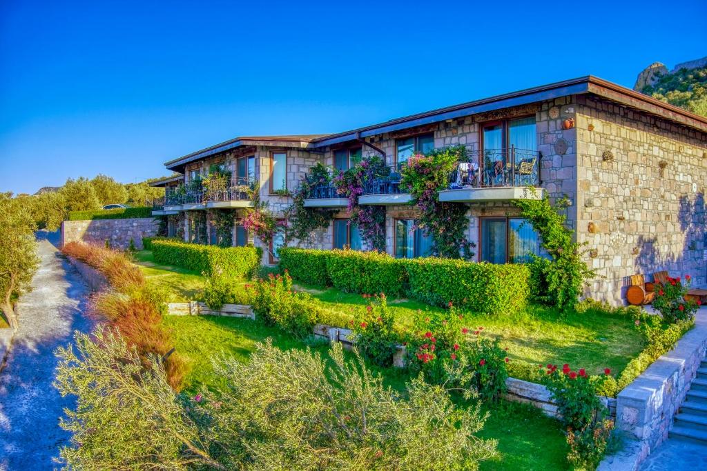 a house with plants on the side of it at Assos Dionysos Special Class Hotel Adults Only 12 years in Behramkale
