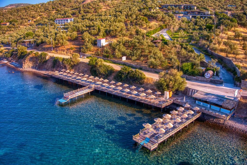 une vue aérienne sur un quai avec des parasols dans l'eau dans l'établissement Assos Dionysos Hotel Adults Only 18, à Assos