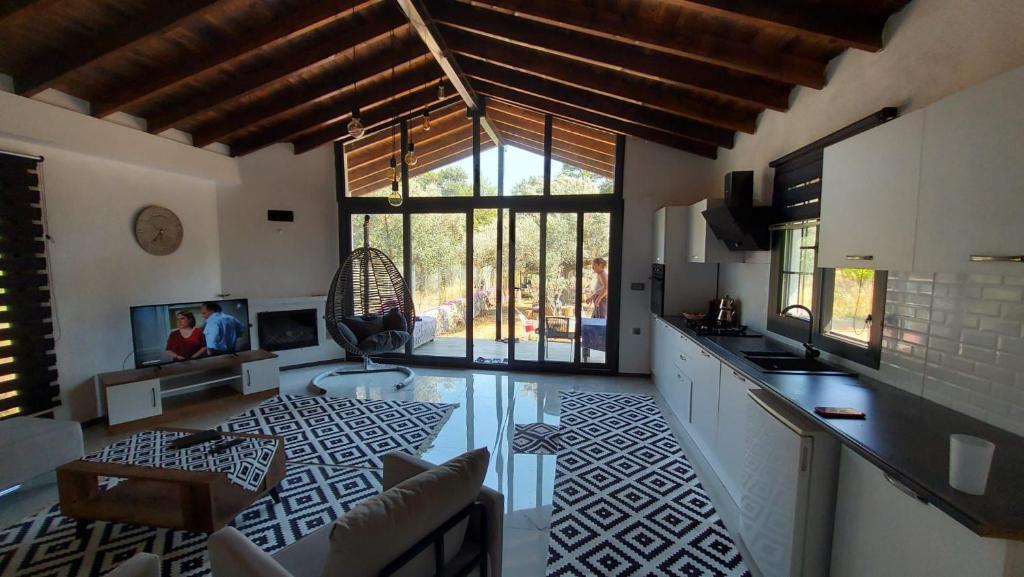 a large kitchen with a large window and a living room at Villa olive junior in Ula