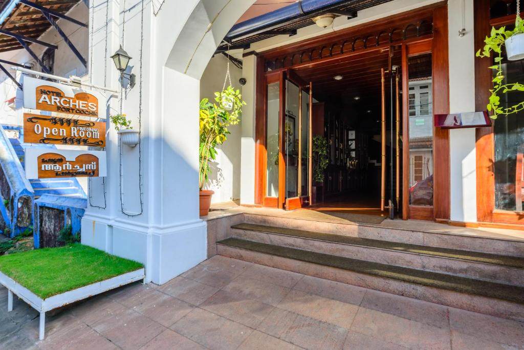 una entrada a una tienda con un banco verde delante en Hotel Arches, en Kochi