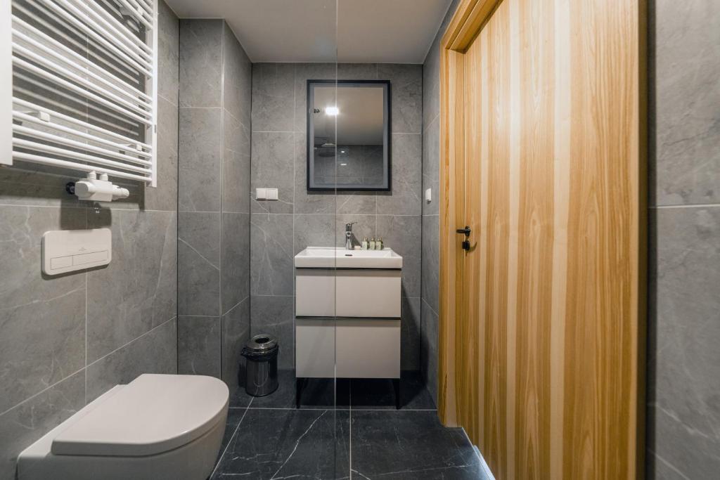 łazienka z toaletą i umywalką w obiekcie Kazalnica Family&Conference Resort w mieście Sosnówka