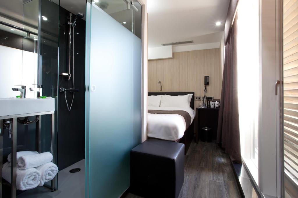 a bathroom with a bed and a shower and a sink at The Z Hotel Soho in London
