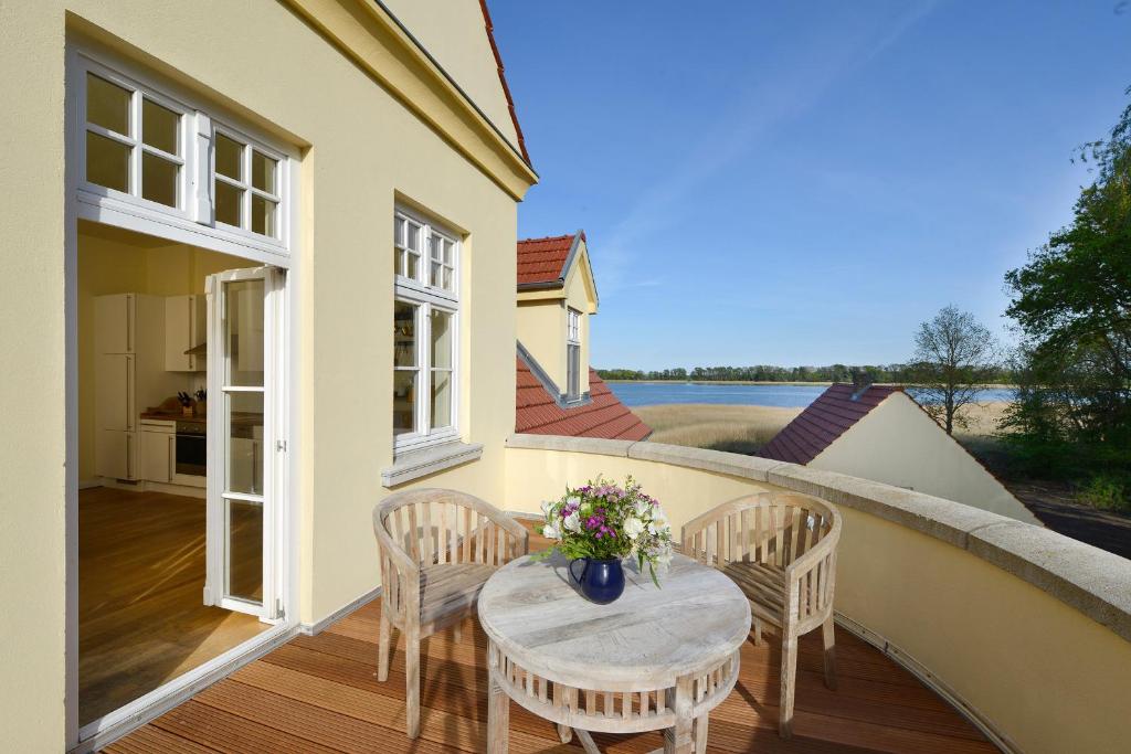 a patio with a table and chairs on a balcony at Ferienwohnung 7 mit Wasserblick, Balkon 2 Pers in Neuenkirchen