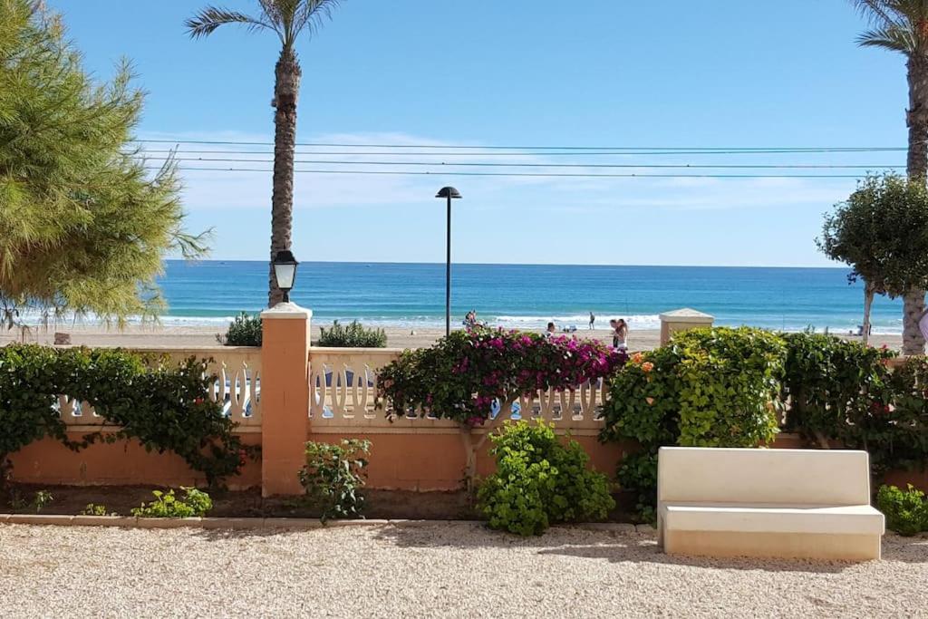 biała ławka siedząca przed plażą w obiekcie Relax en primera linea A w mieście El Campello