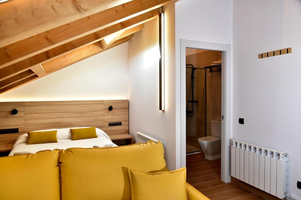 1 dormitorio con cama y almohadas amarillas en ELS 4 PICS, en Puigcerdà