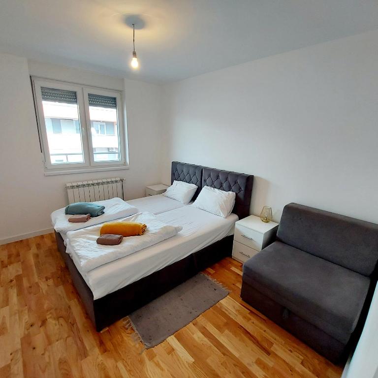 1 Schlafzimmer mit 2 Betten und einem Sofa in der Unterkunft Istocno Sarajevo Lukavica M&M in Donje Mladice
