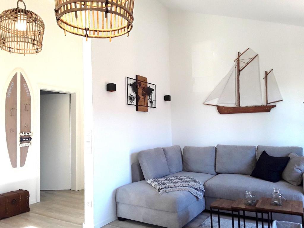 two images of a living room with a blue couch at Nordlicht in Zingst