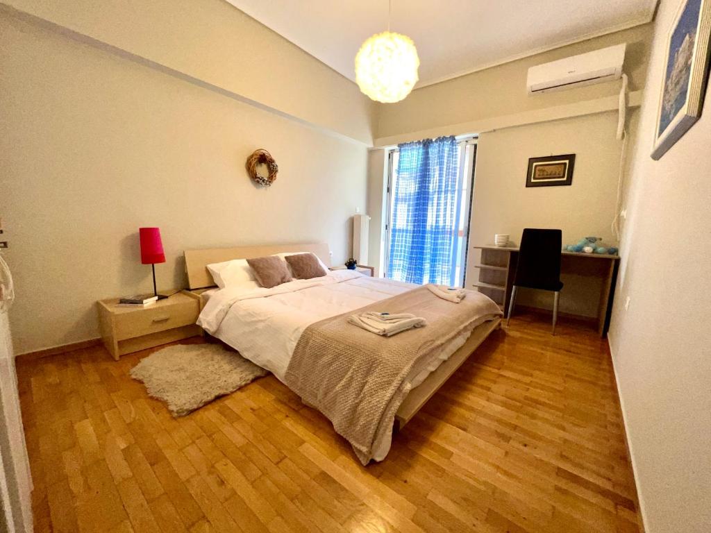 a bedroom with a large bed and a wooden floor at Agios Eleftherios metro st. 2 bedrms 4 pers. flat in Athens