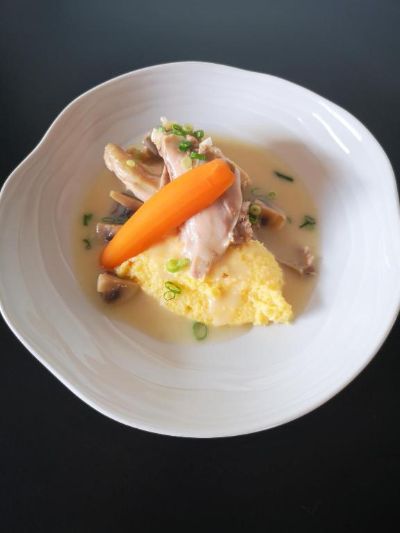 a white plate of food with chicken and a carrot at Logis hôtel Annecy nord &#47; Argonay in Argonay