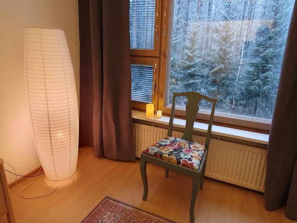 una silla sentada en una habitación con ventana en Apartment Marja's place en Rovaniemi