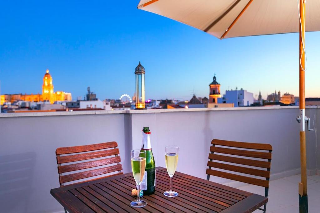 マラガにある-MalagaSunApts-Private Terrace Penthouseのグラス2杯とシャンパン1本付きのテーブル