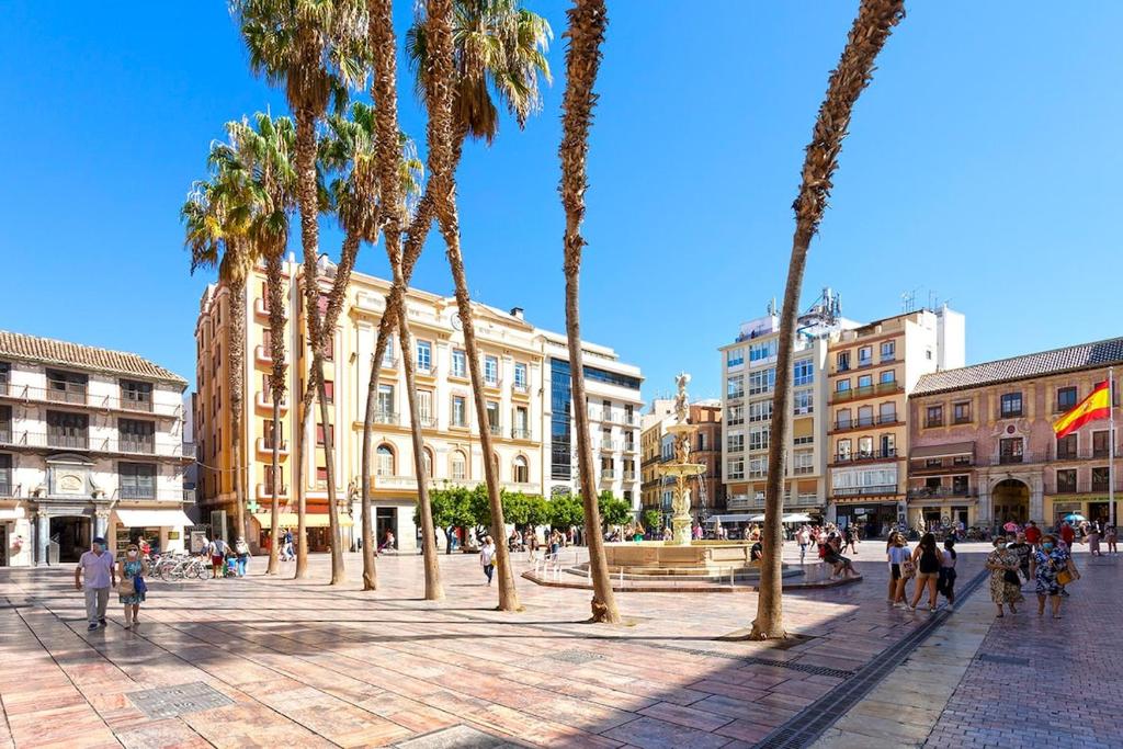 grupa palm na placu z budynkami w obiekcie -MalagaSunApts- Historic Heart of Malaga AA WIFI w Maladze