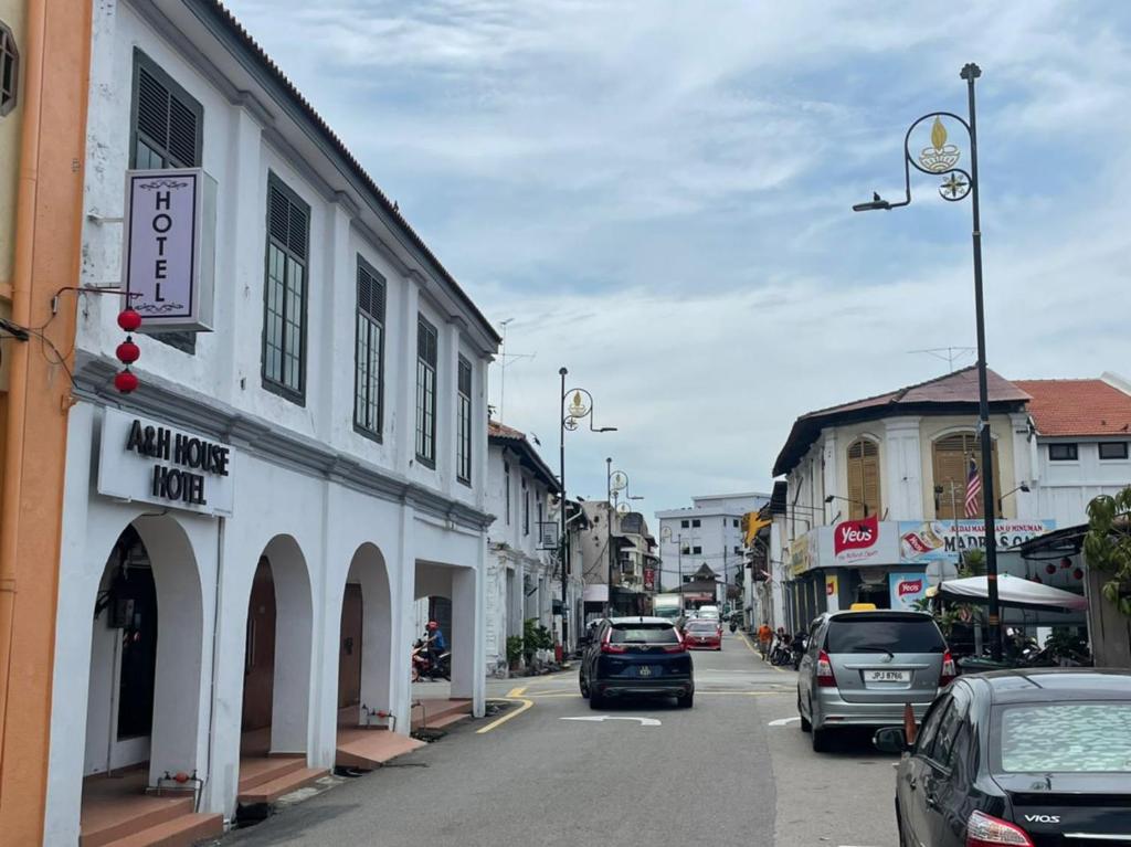 a city street with cars parked on the street at A&H HOUSE HOTEL in Melaka