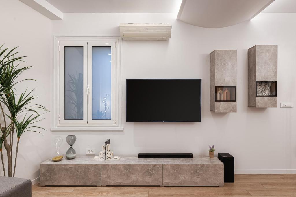 Televízia a/alebo spoločenská miestnosť v ubytovaní Acropolis Holmes Residence
