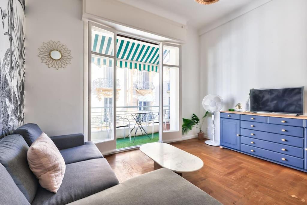 un salon avec un canapé et une télévision dans l'établissement Magnificent apartment - Carré d'or, à Nice