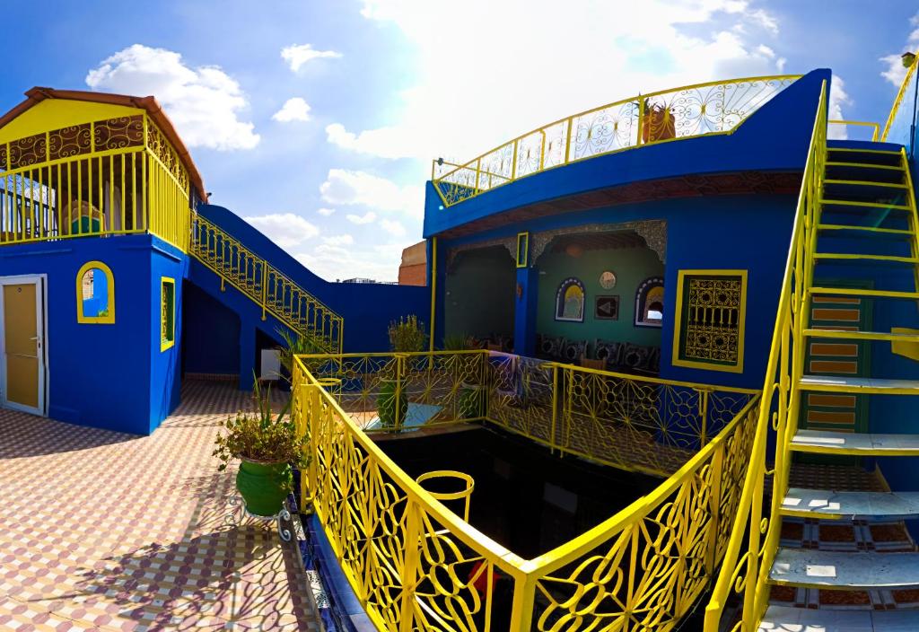 Hotel Medina في مراكش: مبنى ازرق واصفر مع درج اصفر