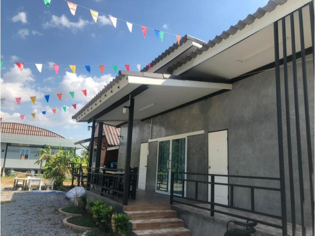 a house with flags hanging from it at Capital O 75412 V Resort in Nakhon Nayok