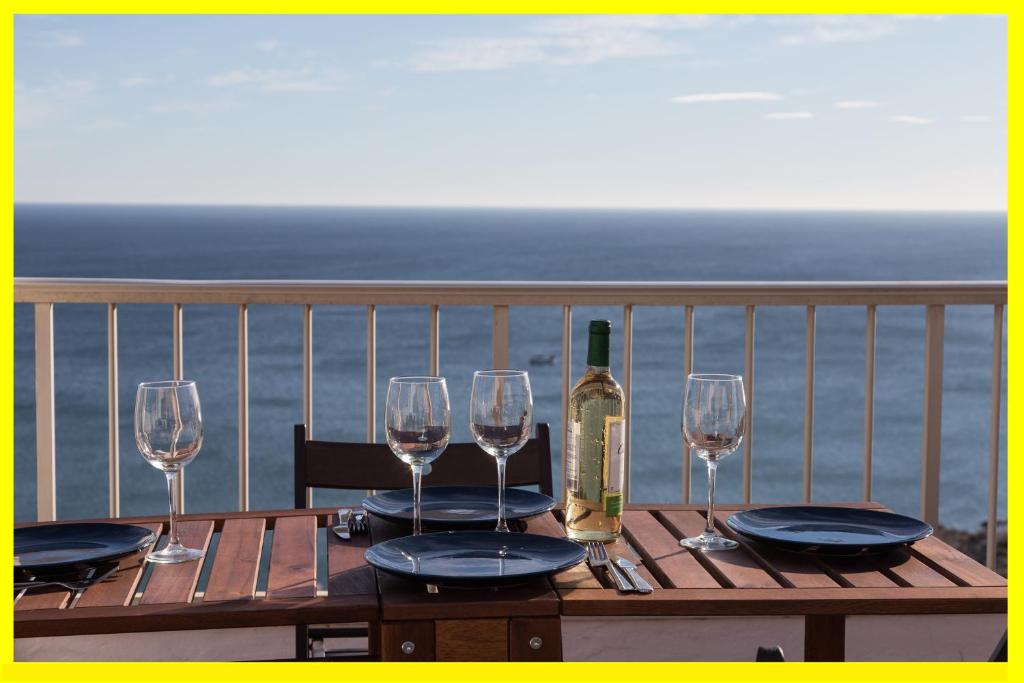 a wooden table with glasses and a bottle of wine at Lighthouse Cullera Penthouse in Cullera