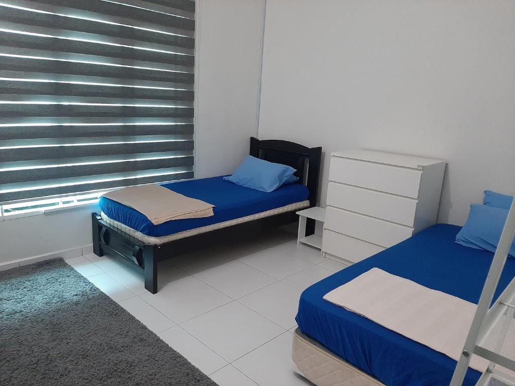 1 dormitorio con 2 camas individuales y ventana en 5Room Home2stay Hayyan Muslim Pool, en Melaka