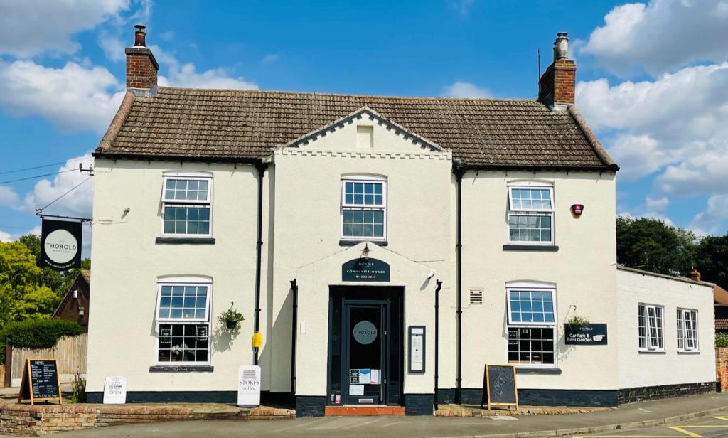 a white house with a black door at The Thorold in Marston