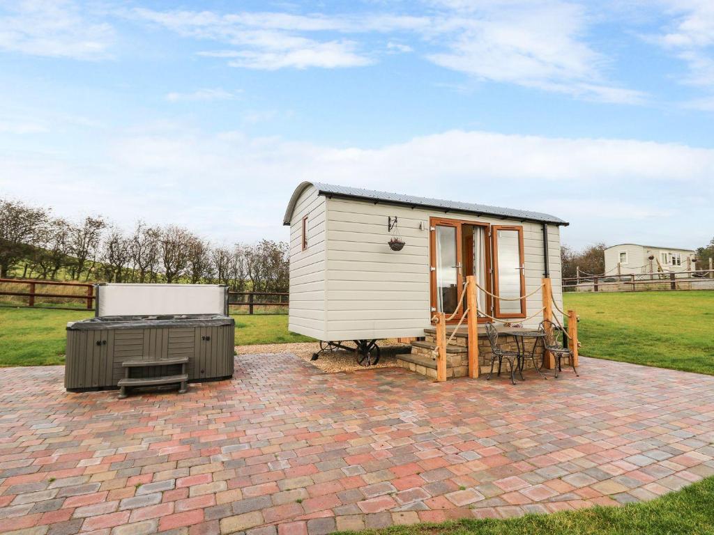 une petite maison blanche sur un patio en briques dans l'établissement Highland View, à Rhayader