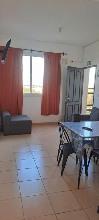 uma sala de estar com uma mesa e um sofá em Sol y Malbec Departamentos em Guaymallén