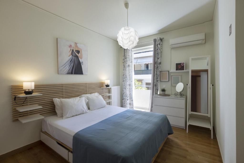 sypialnia z dużym łóżkiem i niebieskim kocem w obiekcie 3BR Prime APT a breath away from the Acropolis! w Atenach