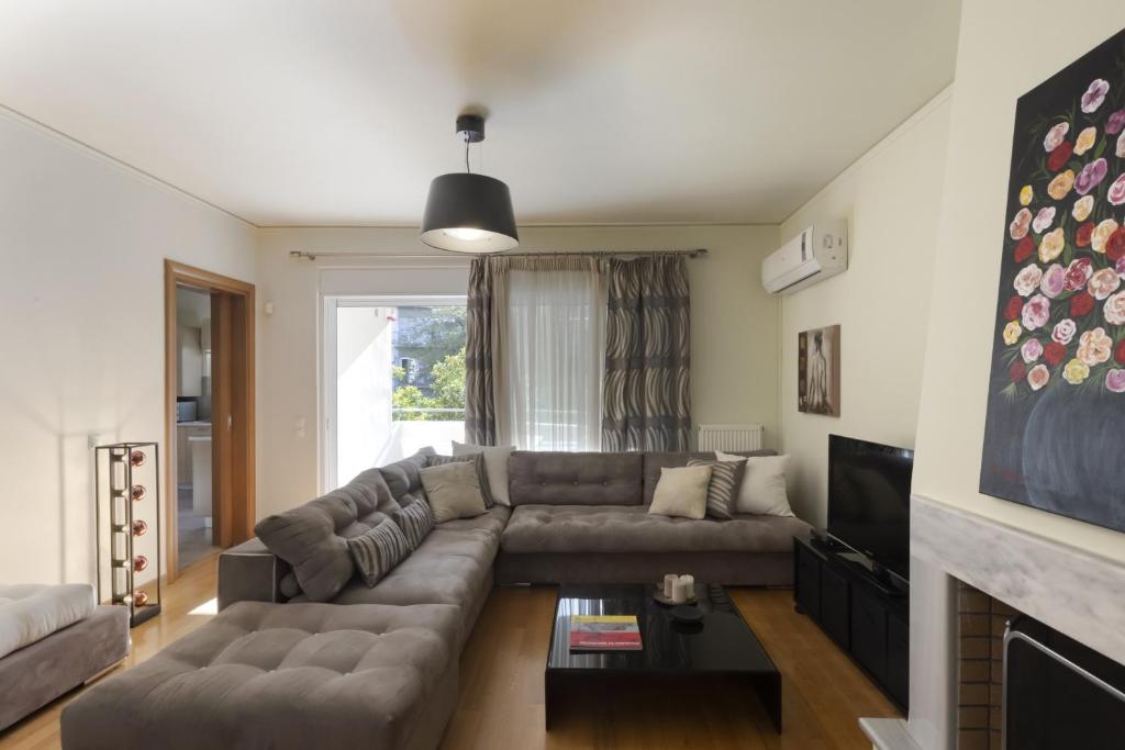 salon z kanapą i telewizorem w obiekcie 3BR Prime APT a breath away from the Acropolis! w Atenach