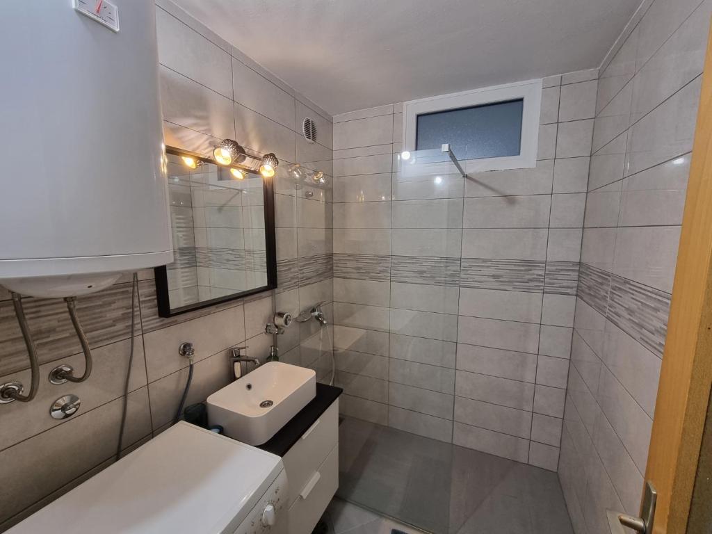 a white bathroom with a sink and a toilet at Apartment Gulek in Zreče