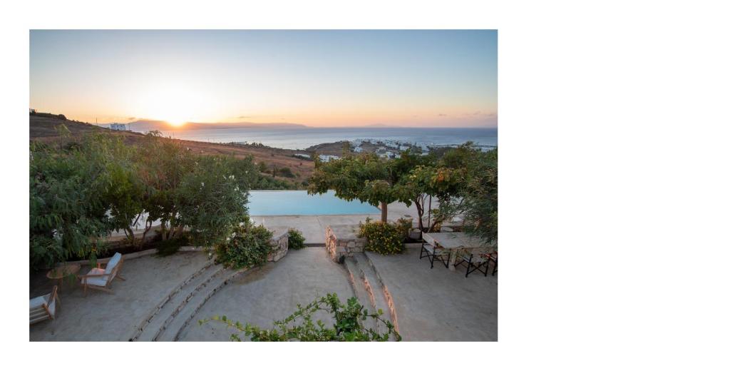 ピソ・リバディにあるMorfia Villasの夕日を背景にビーチの景色を望む客室です。