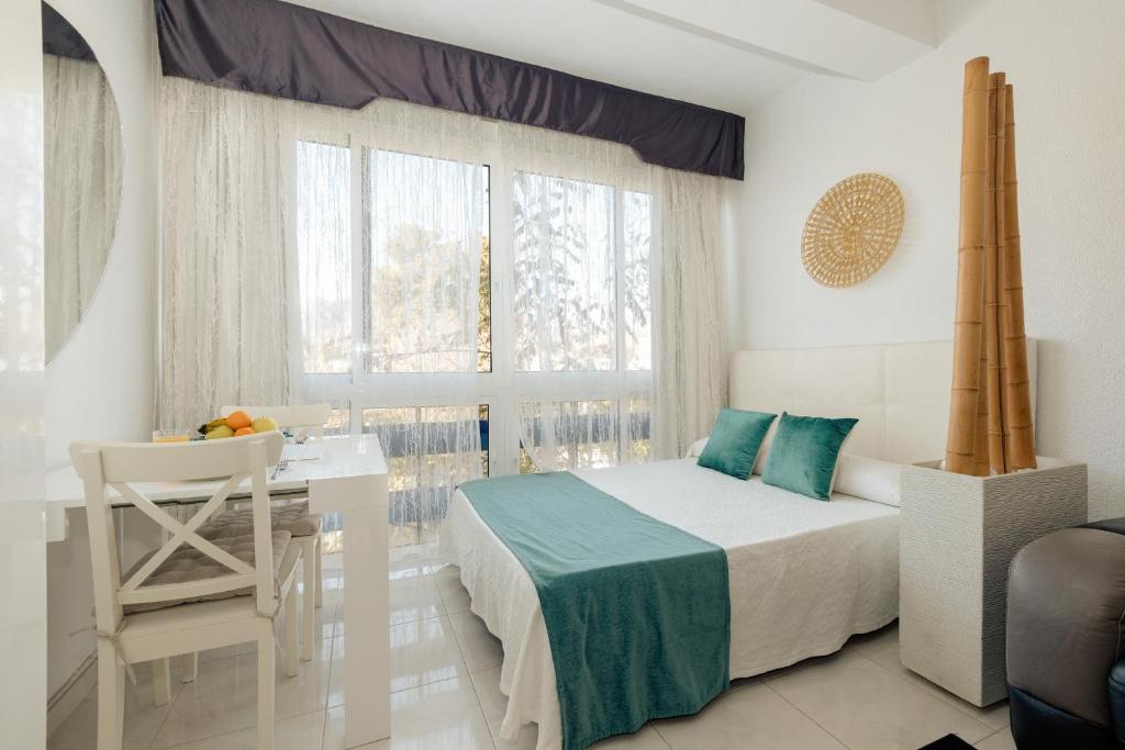 a bedroom with a bed and a desk and a window at Top2Stay Los Alamos in Torremolinos