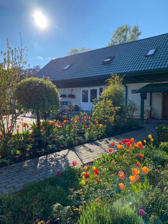 a garden in front of a house with flowers at Searooms Ragaciems in Ragaciems