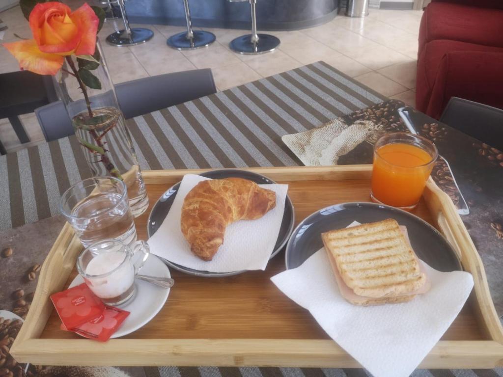 a tray of food with bread and orange juice on a table at B&B Menna Vence in Zumpano