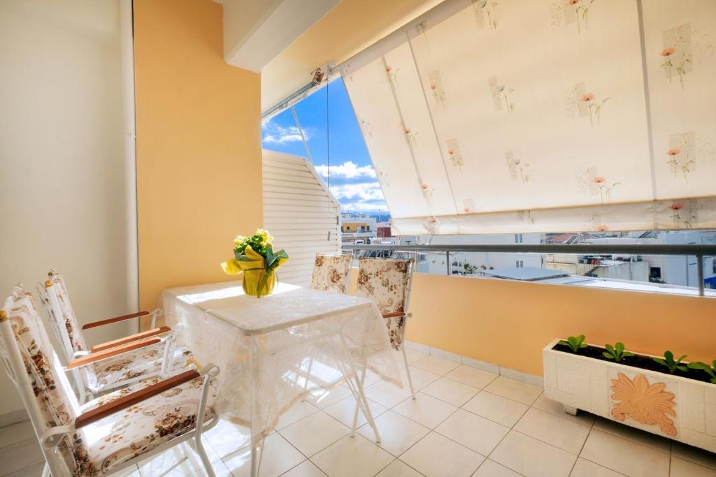jadalnia ze stołem i krzesłami oraz dużym oknem w obiekcie Port Apartment w Chanii